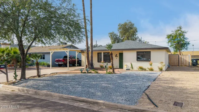 a front view of a house with garden and trees