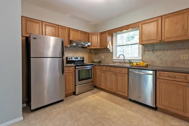 a kitchen with stainless steel appliances granite countertop a refrigerator sink and stove