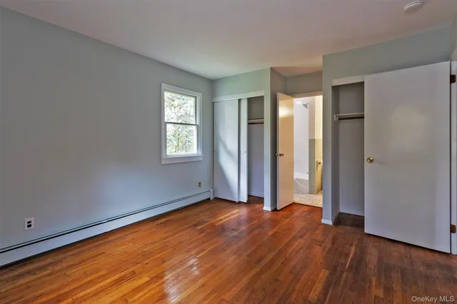 an empty room with wooden floor and window