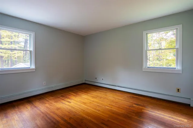 a view of a room with wooden floor and a window