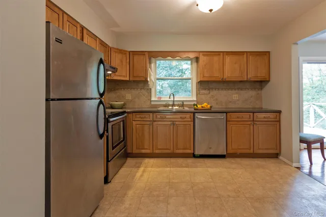 a kitchen with stainless steel appliances a refrigerator sink and cabinets