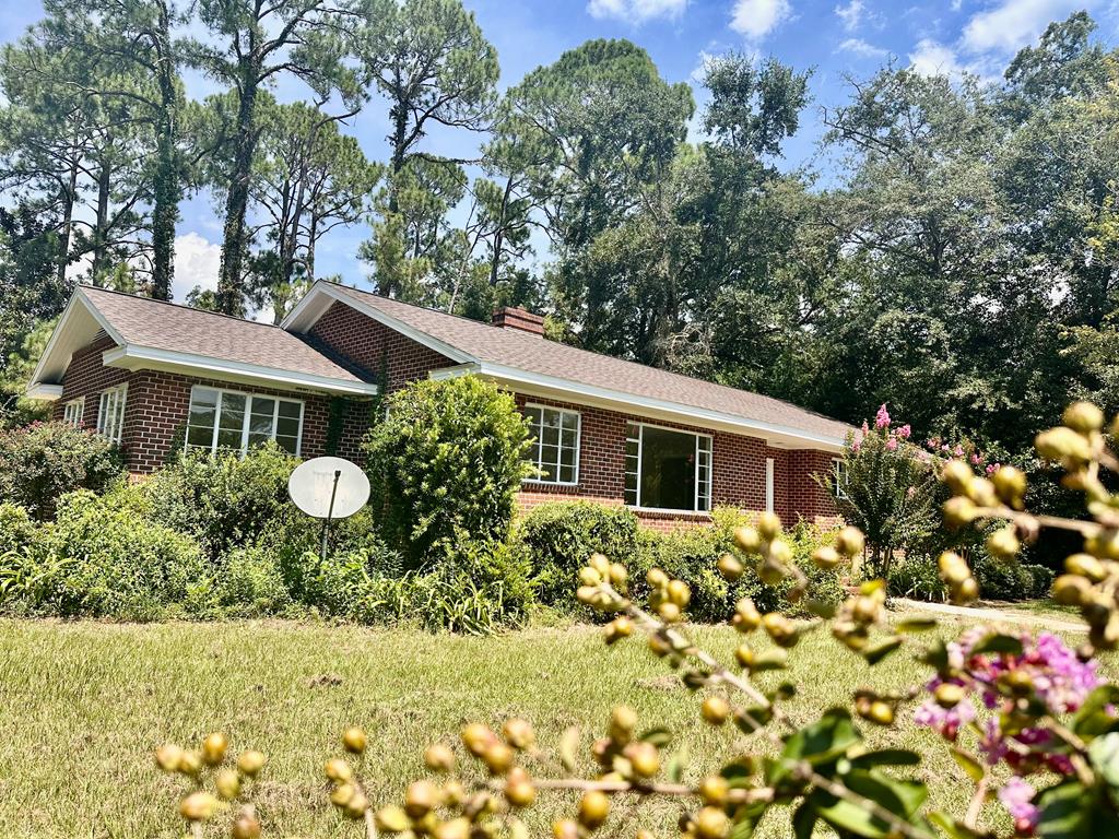 a front view of a house with a yard and fountain in middle