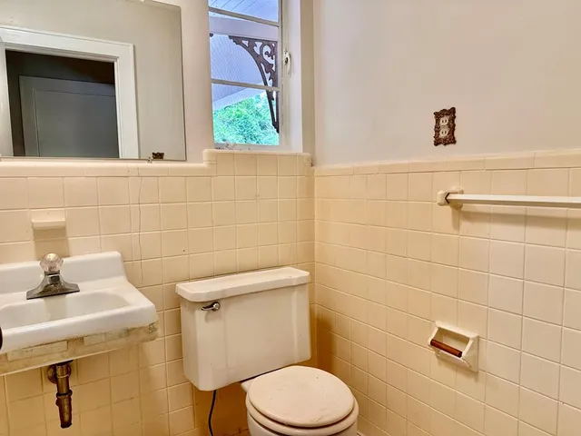 a bathroom with a sink a toilet and a mirror