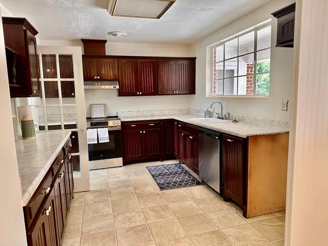 a kitchen with stainless steel appliances granite countertop a sink counter space cabinets and a window