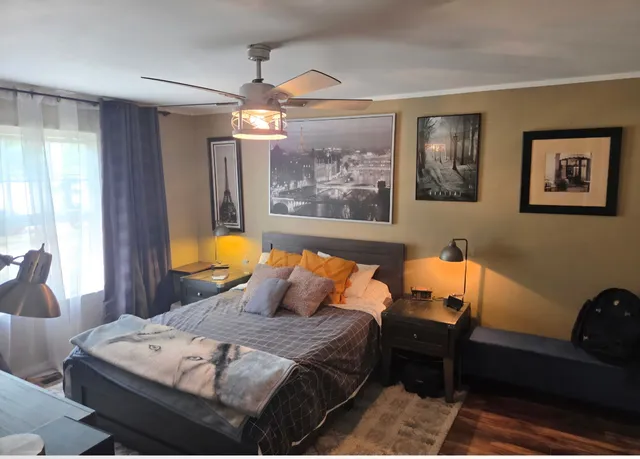 a bedroom with a bed and wooden floor