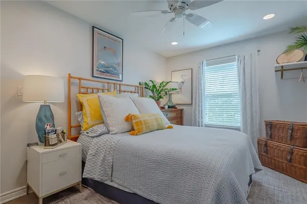 a bedroom with a bed a couch and potted plant