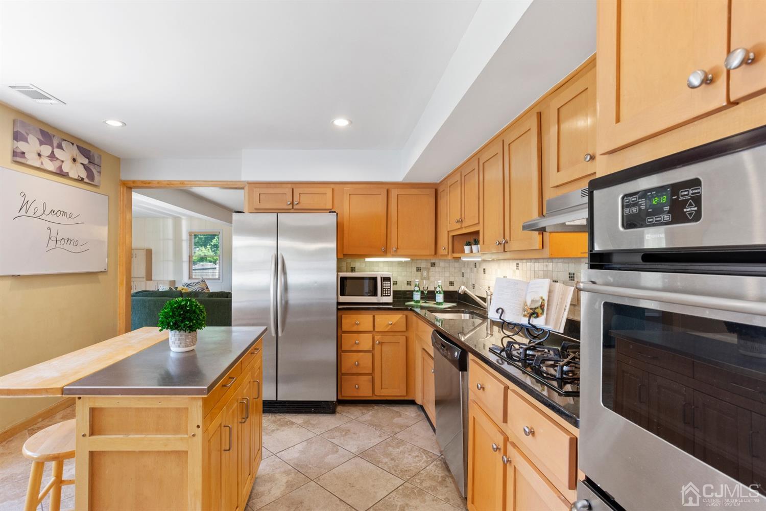 15 Tar Heels Road Hamilton, NJ 08619 - Photo 15 of 46 a kitchen with stainless steel appliances granite countertop a stove top oven a refrigerator a sink and dishwasher with wooden floor