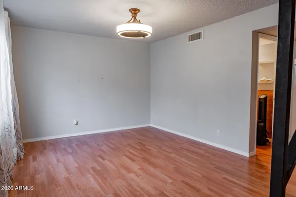 a view of empty room with wooden floor and fan