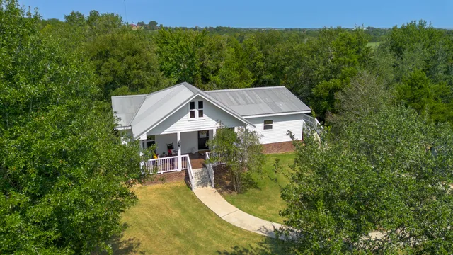 an aerial view of a house with swimming pool and garden