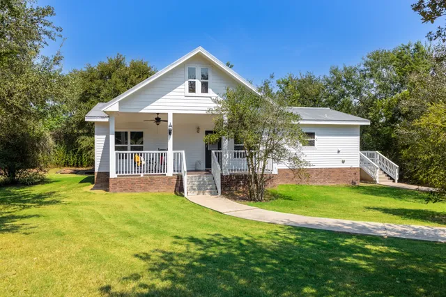 a view of a house with a yard and sitting area