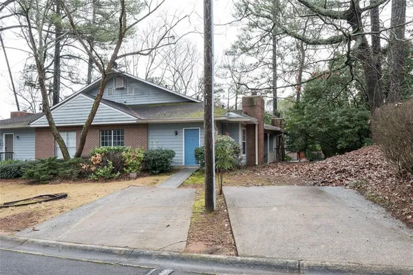 a front view of a house with a yard and potted plants