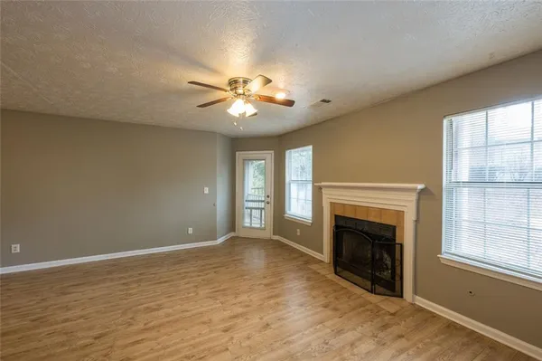 a view of empty room with fireplace and fan