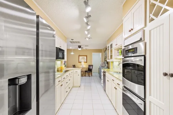 a large kitchen with stainless steel appliances granite countertop a stove and a refrigerator