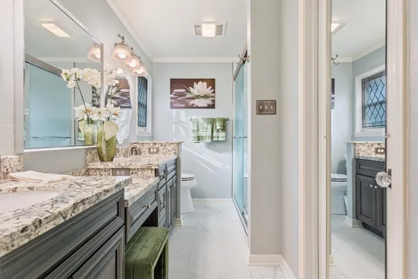 a bathroom with a granite countertop sink a mirror and shower