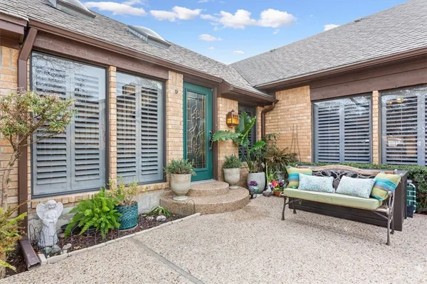 a living room with patio furniture and potted plants