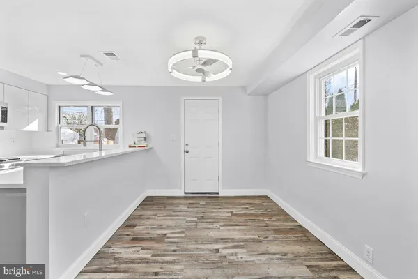 a view of a kitchen with a sink dishwasher and wooden floor