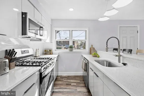 a kitchen with stainless steel appliances a sink stove and cabinets
