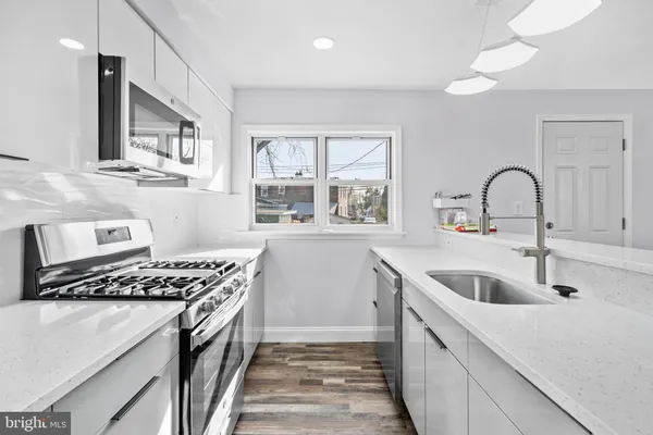 a kitchen with sink a stove and cabinets