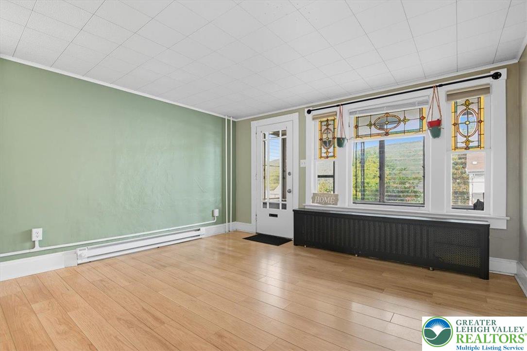 229 West High Street Nesquehoning, PA 18240 - Photo 7 of 38 an empty room with wooden floor and windows