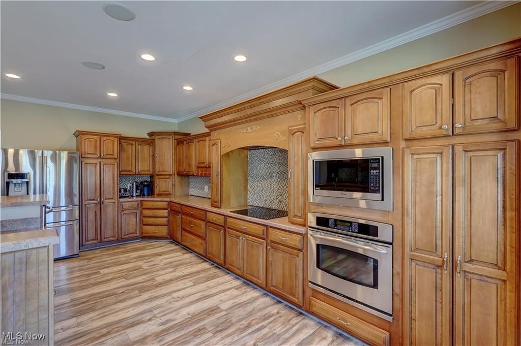 3079 Alexander Road Atwater, OH 44201 - Photo 9 of 45 Kitchen with stainless steel appliances, ornamental molding, wood finish cabinets, recessed lighting, and light wood-style flooring