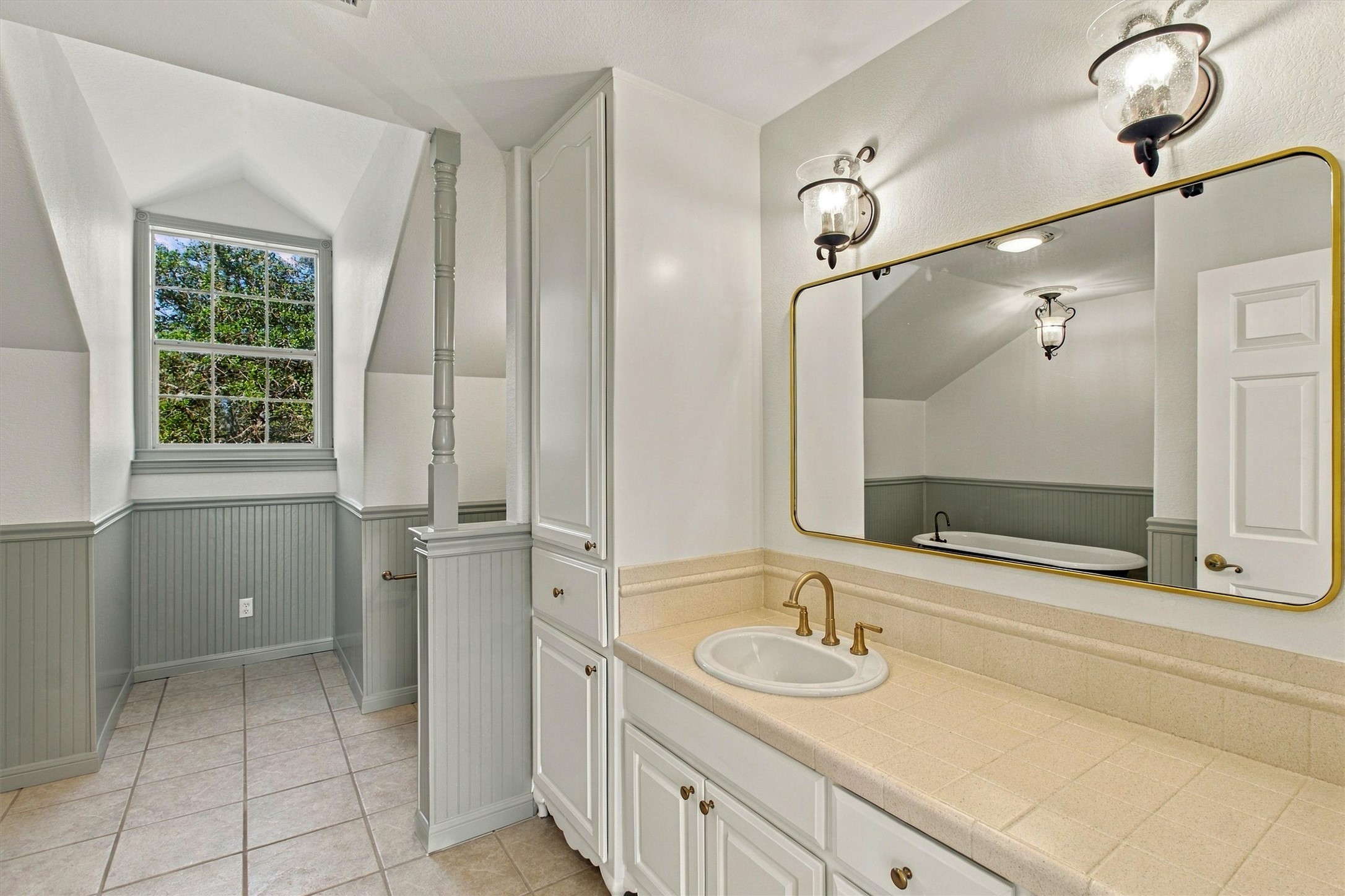 1651 Old Red Ranch Road Dripping Springs, TX 78620 - Photo 20 of 31 Classic wainscoting and tiled counters define this bath with its integrated built-in cabinetry.