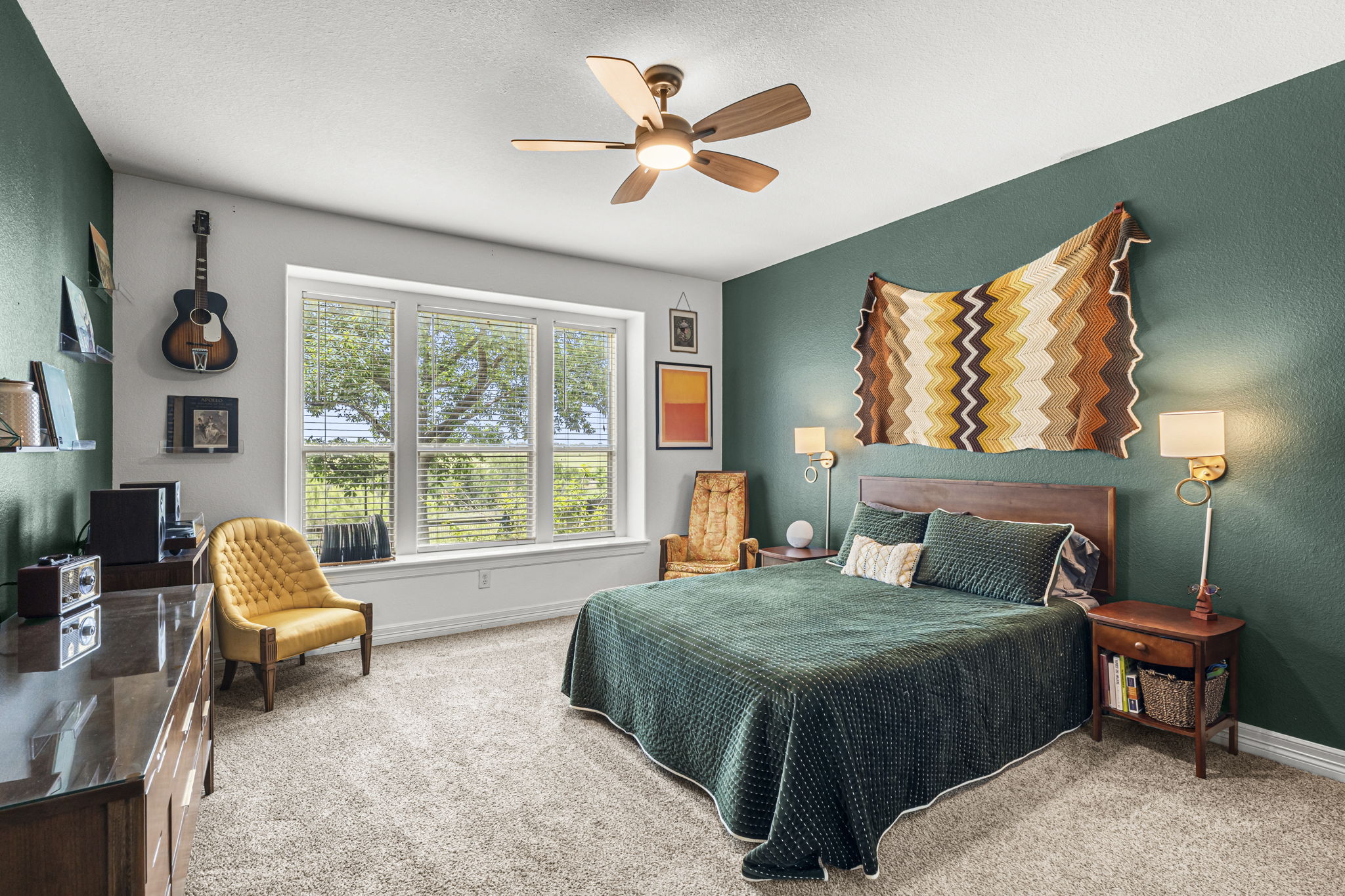 454 Fall Circle Kyle, TX 78640 - Photo 17 of 39 Sun-filled bedroom features a ceiling fan, plush carpeting, and views of the surrounding natural landscape.