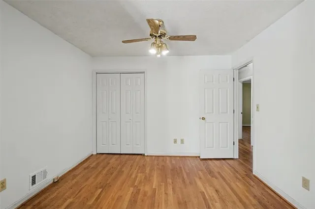 a view of room with wooden floor and ceiling fan