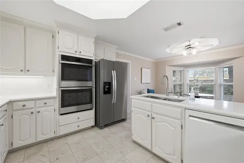 a kitchen with white cabinets and stainless steel appliances