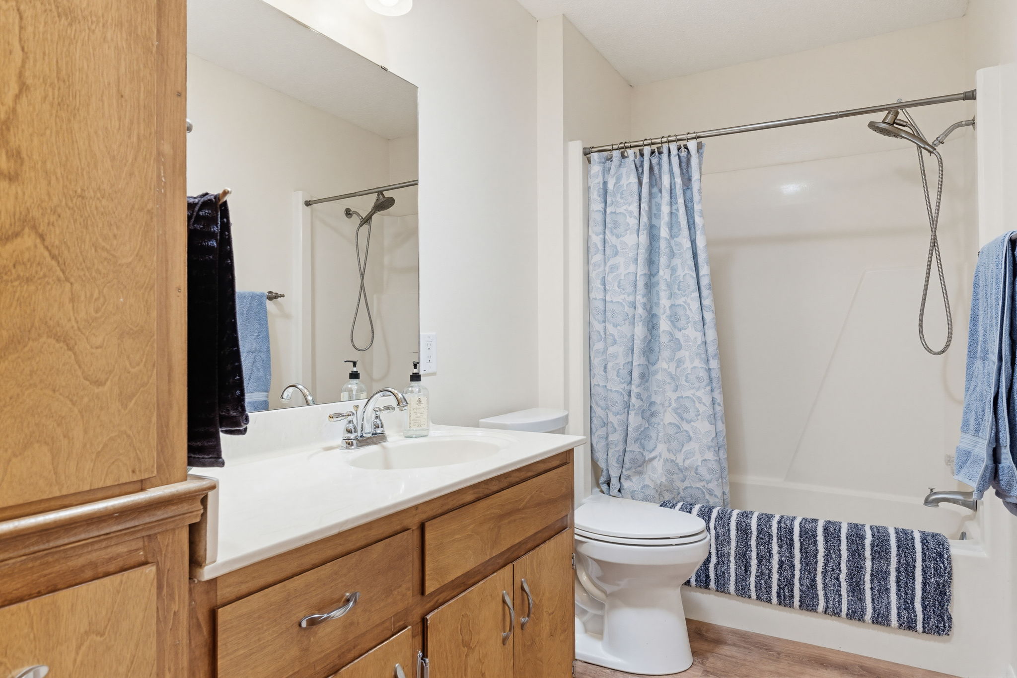 120 Rae Lane Jarrell, TX 76537 - Photo 30 of 40 Bathroom featuring a wood-finish vanity with a light-colored countertop, an undermount sink, and a chrome faucet