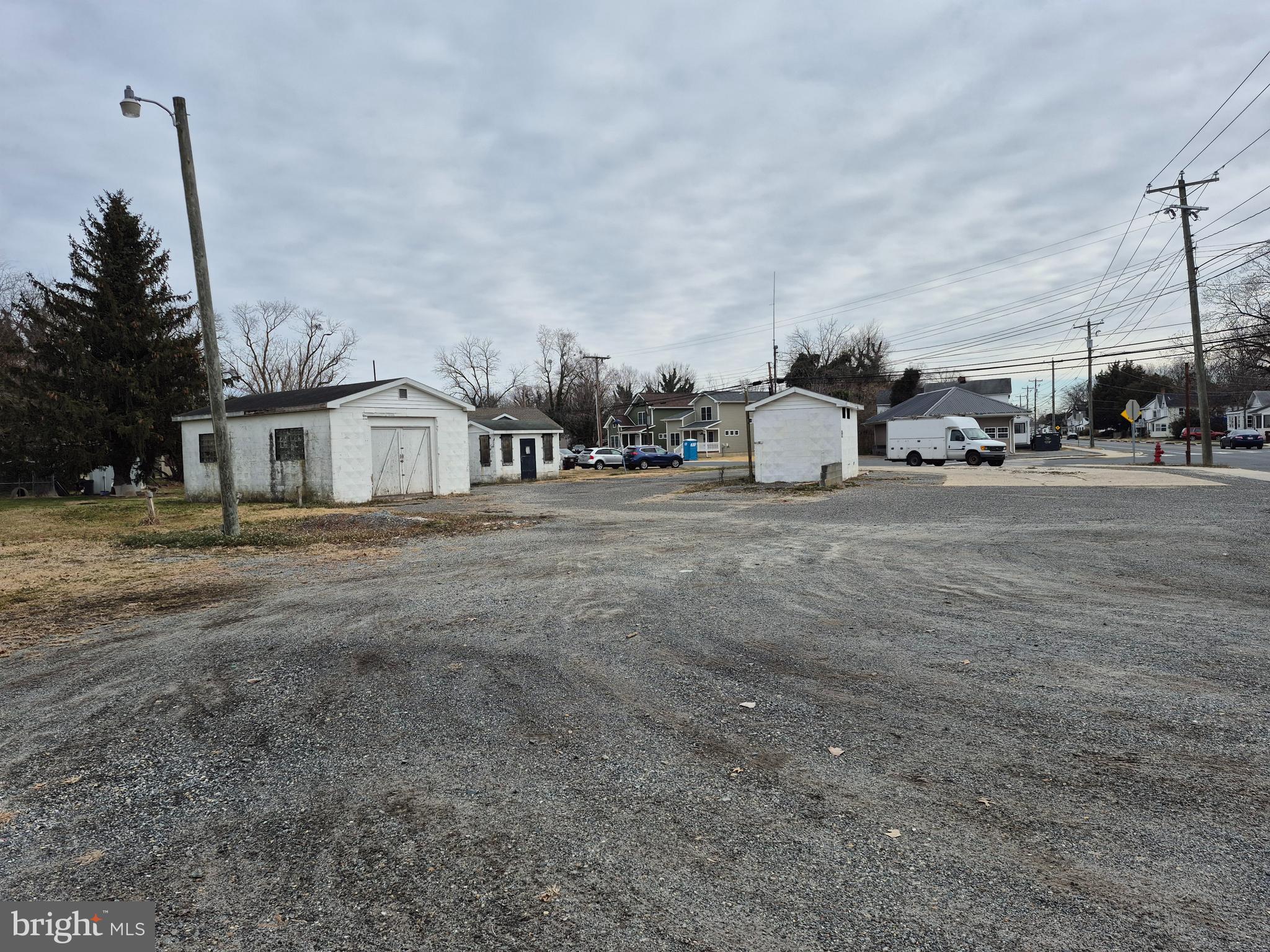 High Street Cambridge, MD 21613 - Photo 3 of 6 a white house with a large trees next to a road