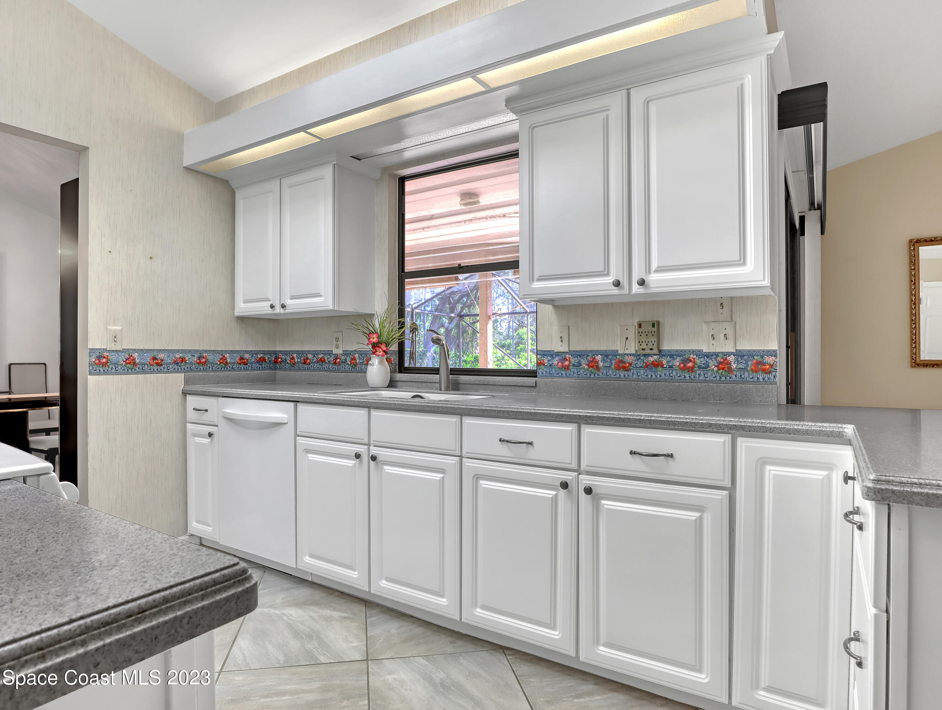 705 Casa Grande Drive Melbourne, FL 32940 - Photo 11 of 32 a kitchen with white cabinets and sink