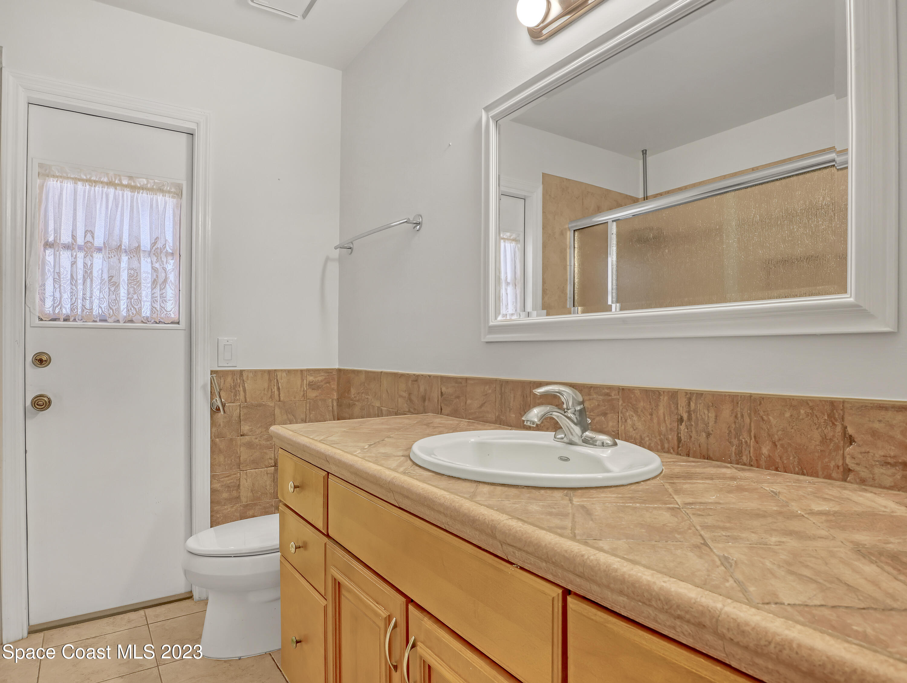 705 Casa Grande Drive Melbourne, FL 32940 - Photo 21 of 32 a bathroom with a sink a toilet and a mirror