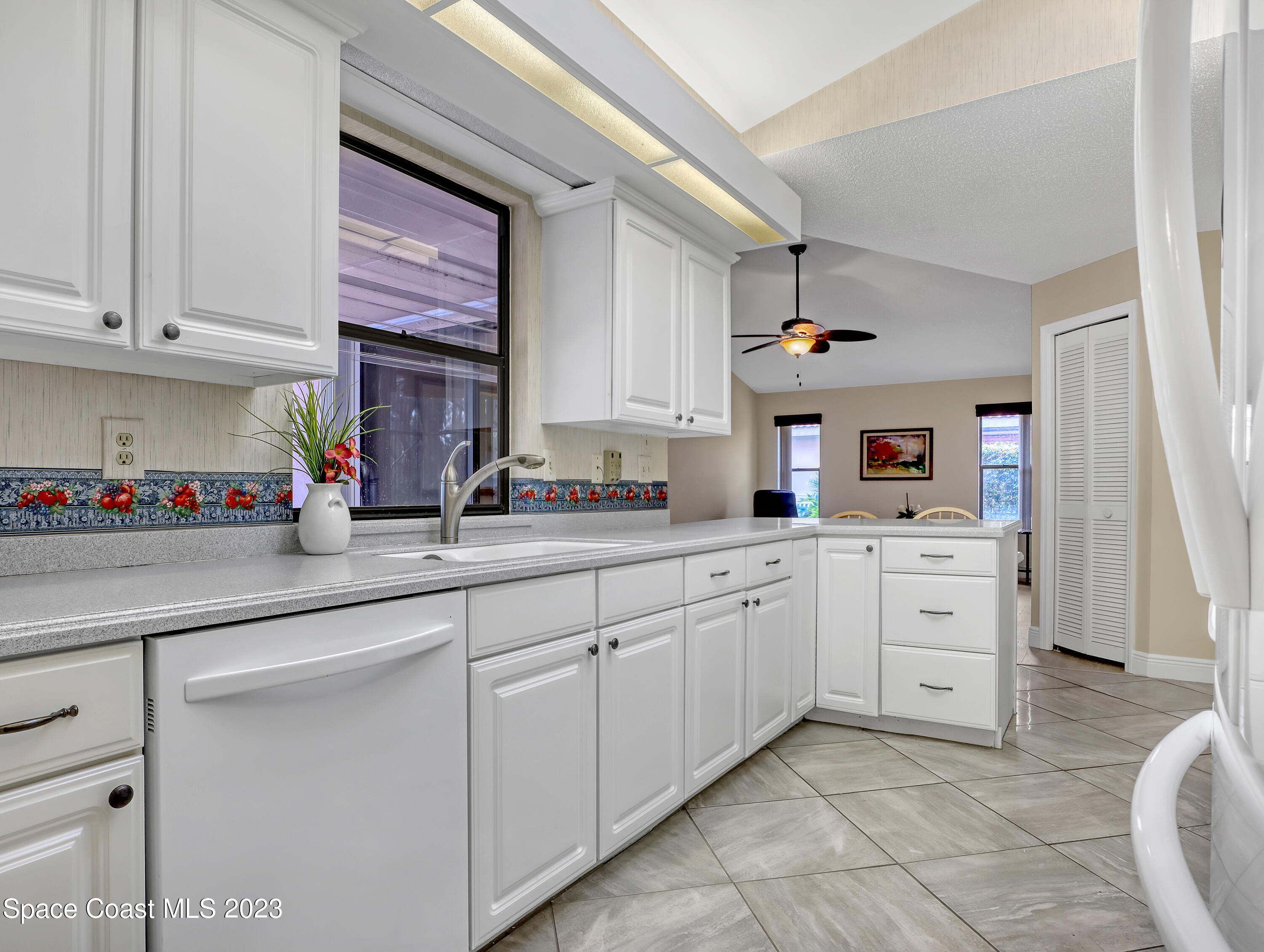 705 Casa Grande Drive Melbourne, FL 32940 - Photo 10 of 32 a kitchen with white cabinets and sink