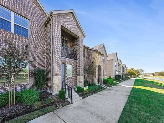 a front view of a house with a yard and trees