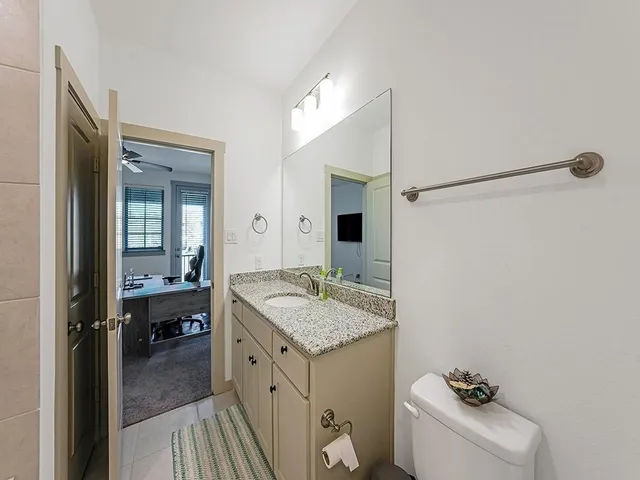 a bathroom with a granite countertop sink and a mirror