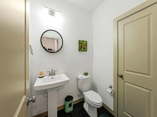 a bathroom with a sink toilet and a mirror