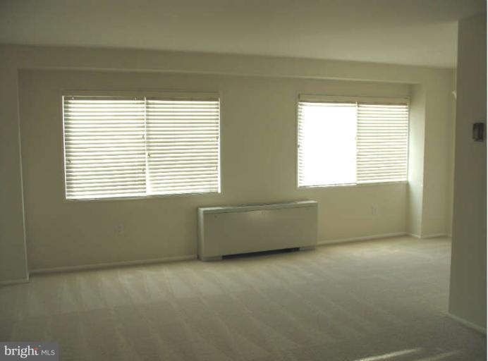 1111 University Boulevard West, Unit 1014 Silver Spring, MD 20902 - Photo 4 of 8 a room with a window and a chair