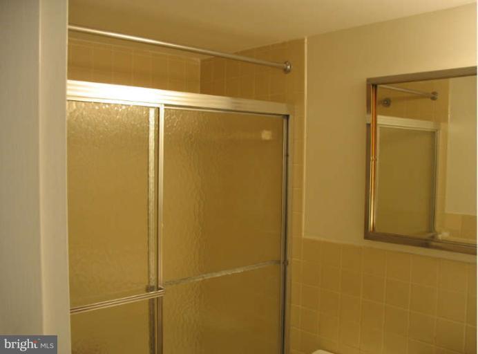 1111 University Boulevard West, Unit 1014 Silver Spring, MD 20902 - Photo 5 of 8 a bathroom with a glass shower door