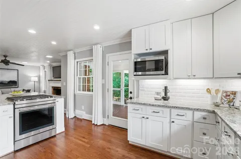 a kitchen with stainless steel appliances granite countertop a stove a sink and a microwave