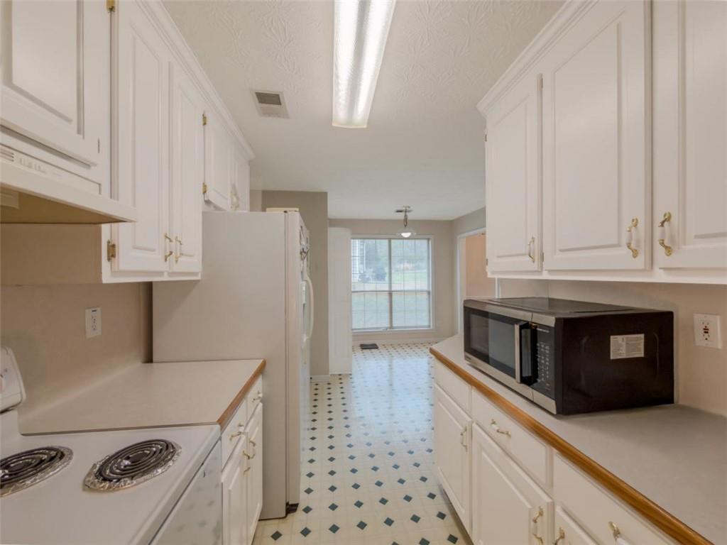 30 Cinnamon Fern Circle Covington, GA 30016 - Photo 11 of 27 a kitchen with stainless steel appliances a refrigerator a stove and white cabinets