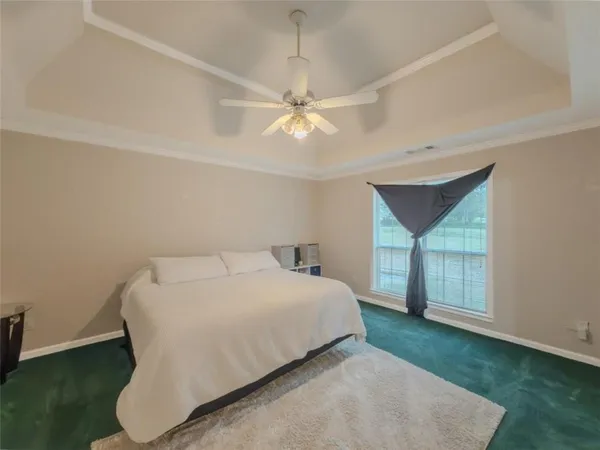 a bedroom with a bed and a ceiling fan