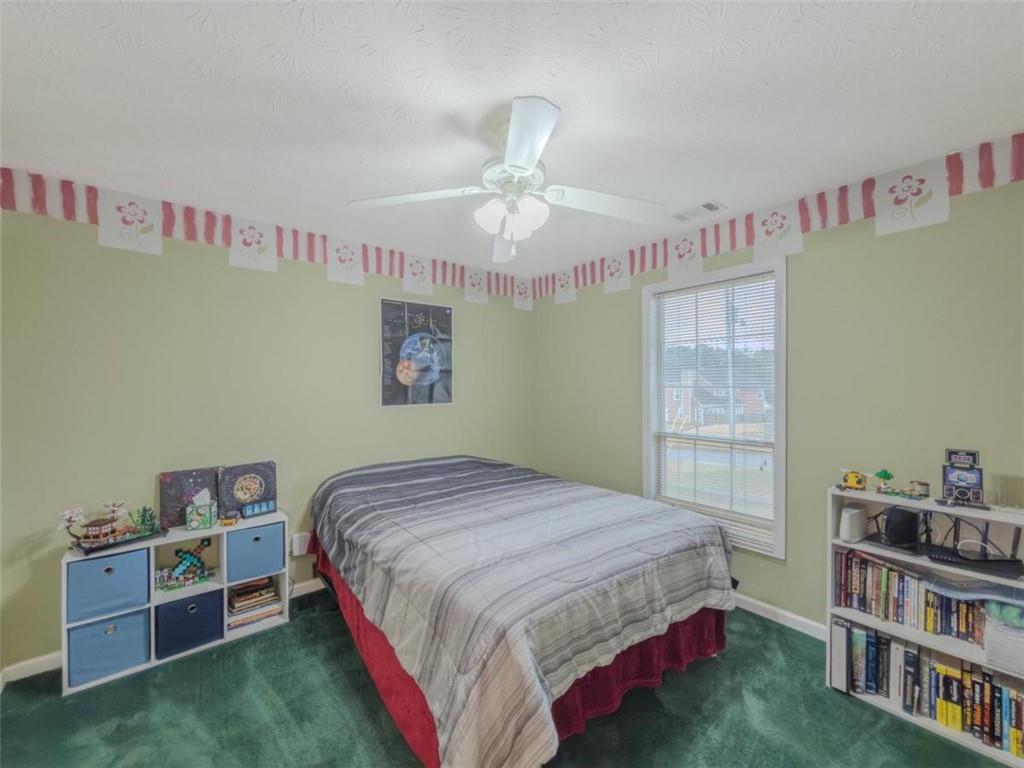 30 Cinnamon Fern Circle Covington, GA 30016 - Photo 14 of 27 a bedroom with a bed and a book shelf