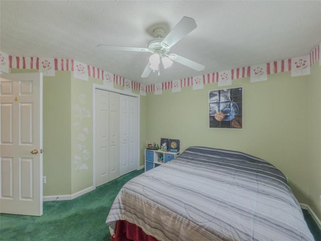 30 Cinnamon Fern Circle Covington, GA 30016 - Photo 15 of 27 a bedroom with a bed and a chandelier