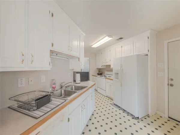 a kitchen with sink cabinets and refrigerator
