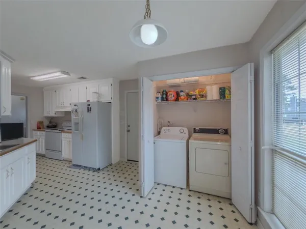 a room with a baby crib and a refrigerator