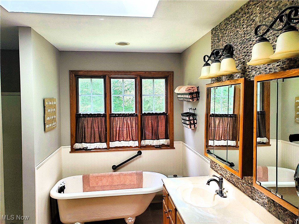 8329 Seasons Road Streetsboro, OH 44241 - Photo 18 of 35 Bathroom with a bathing tub, a skylight, and vanity