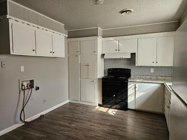 a kitchen with a refrigerator and white cabinets