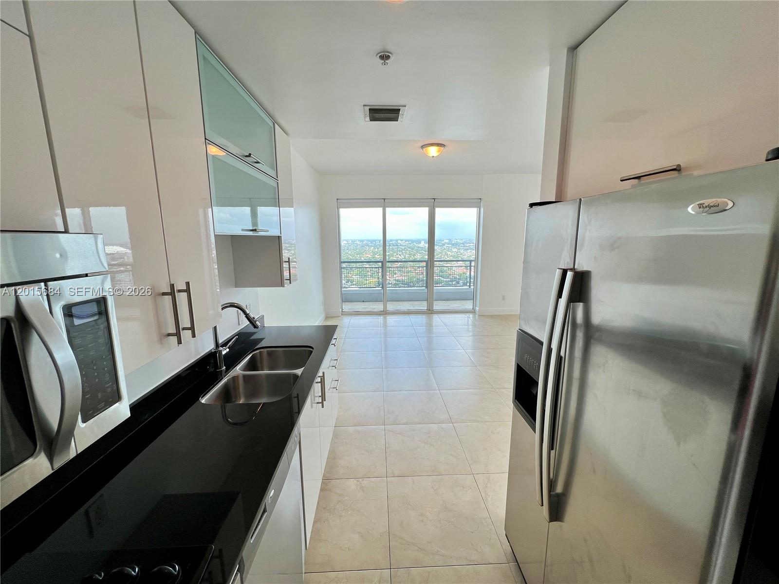 60 Southwest 13th Street, Unit 3609 Miami, FL 33130 - Photo 4 of 24 a kitchen with a refrigerator and a sink