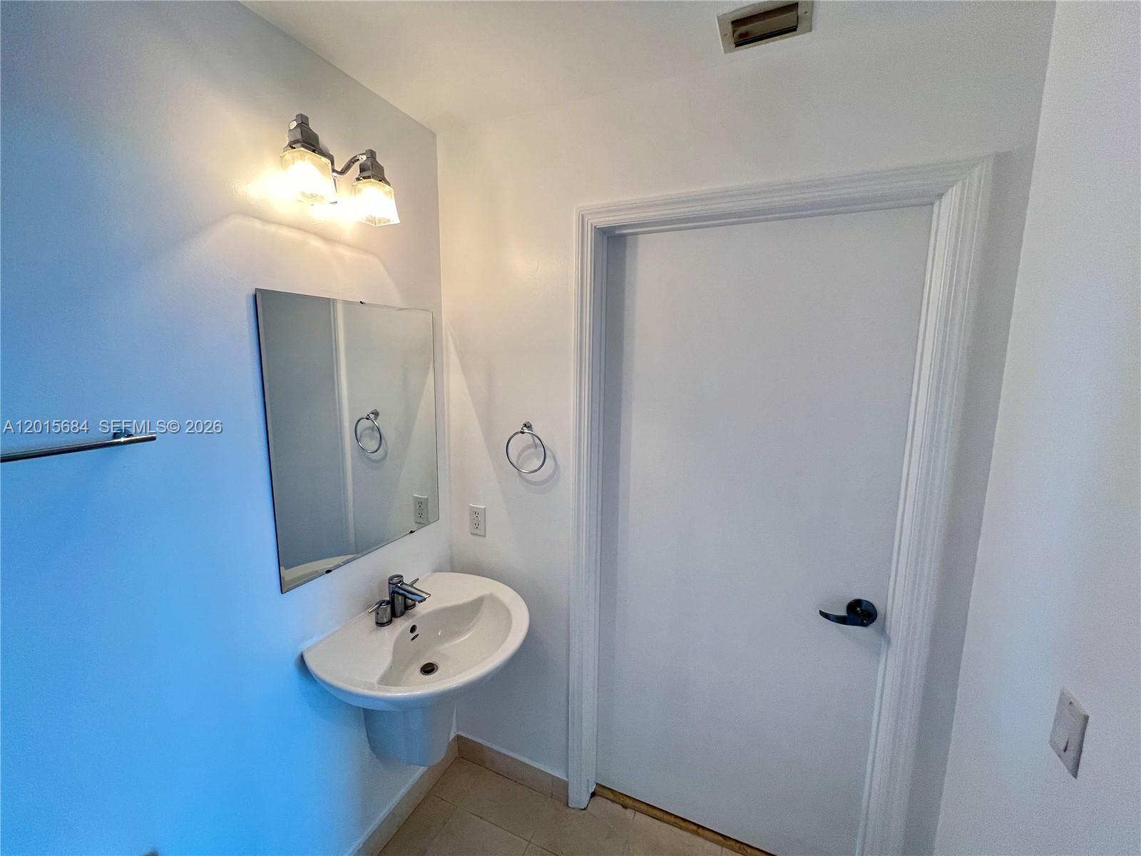 60 Southwest 13th Street, Unit 3609 Miami, FL 33130 - Photo 7 of 24 a bathroom with a sink a light fixture and a mirror