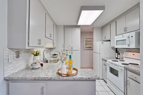 a kitchen with white cabinets and a sink